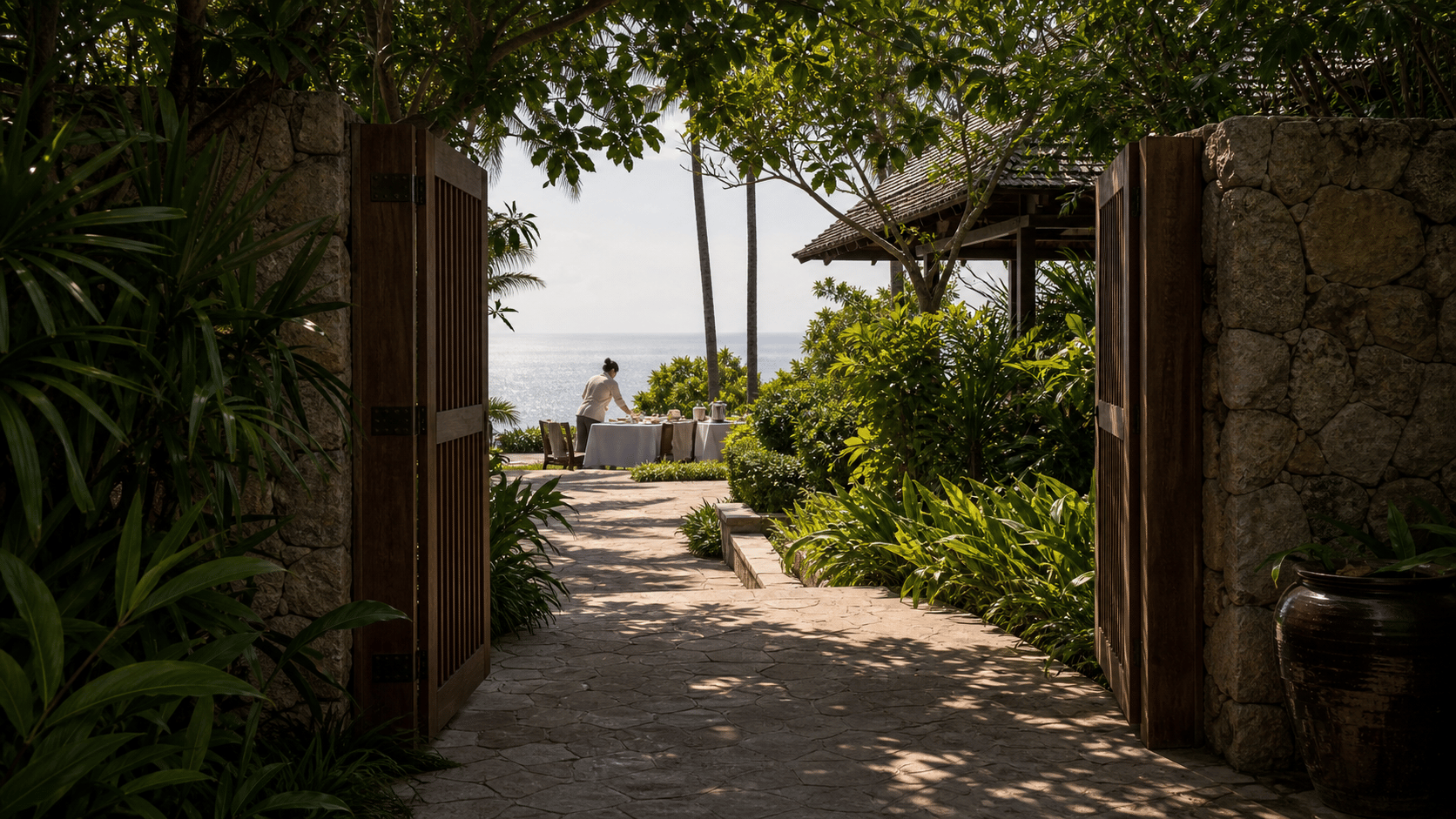 Phuket Estates vs. Amanpuri shown as secluded Phuket estate gate arrival for VIAIVE, with private gate, local stone, villa staff preparation.