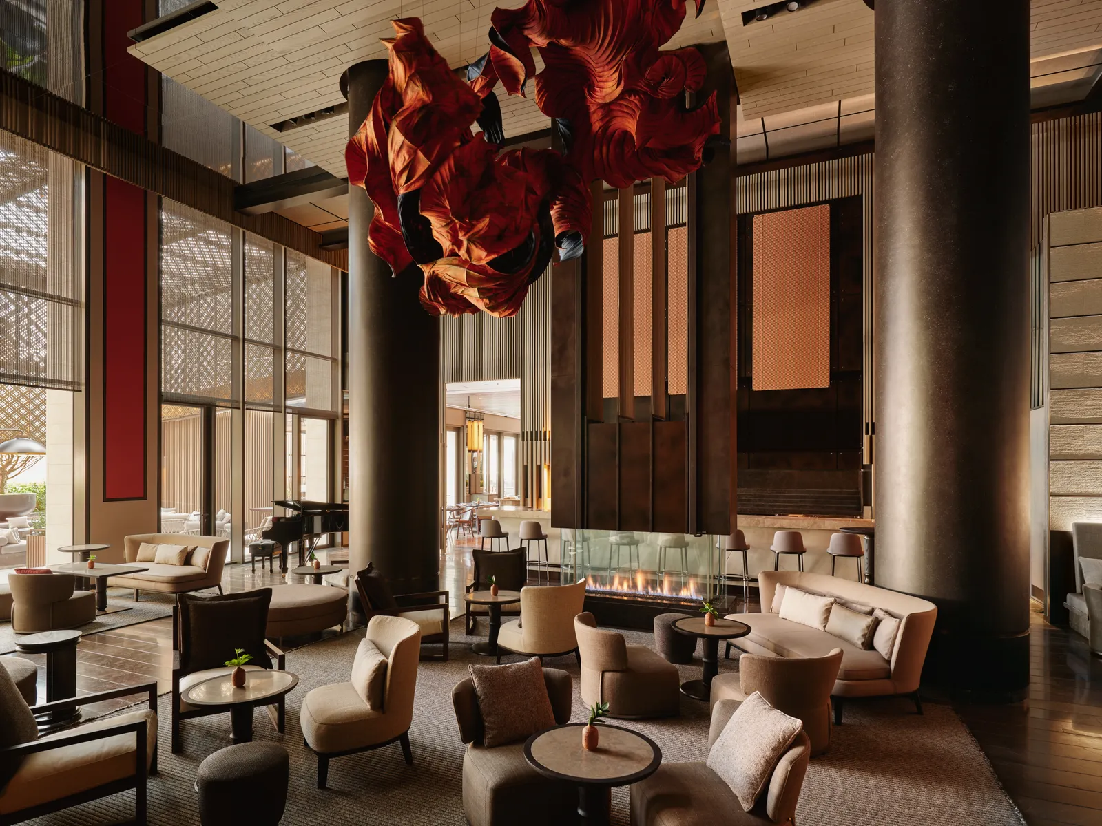 Bar and lounge at Aman New York with sculptural ceiling art and a fireplace