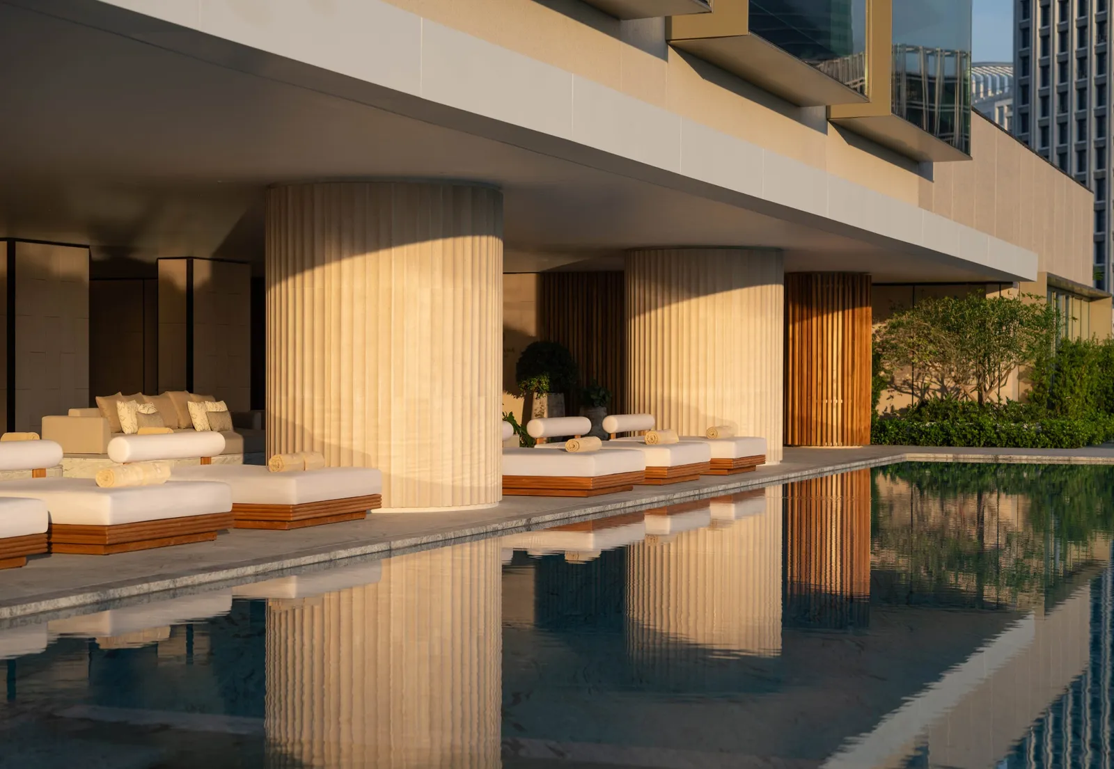 Outdoor pool at Dusit Thani Bangkok framed by greenery and city towers