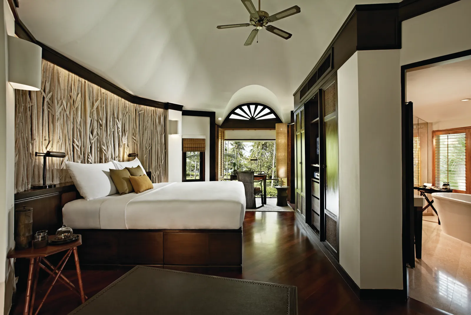 The bedroom of a Deluxe Pavilion at Rayavadee, with an en-suite bathtub visible beyond.