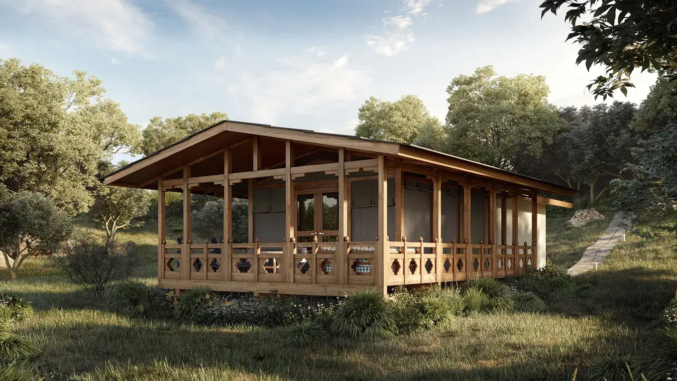 The exterior of a guest tent at andBeyond Punakha River Lodge, set among trees on the property.