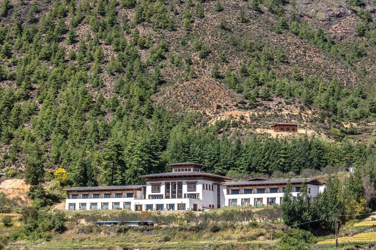 Bhutan Spirit Sanctuary's traditional-style lodge building set against the forested slopes of the Neyphu Valley near Paro