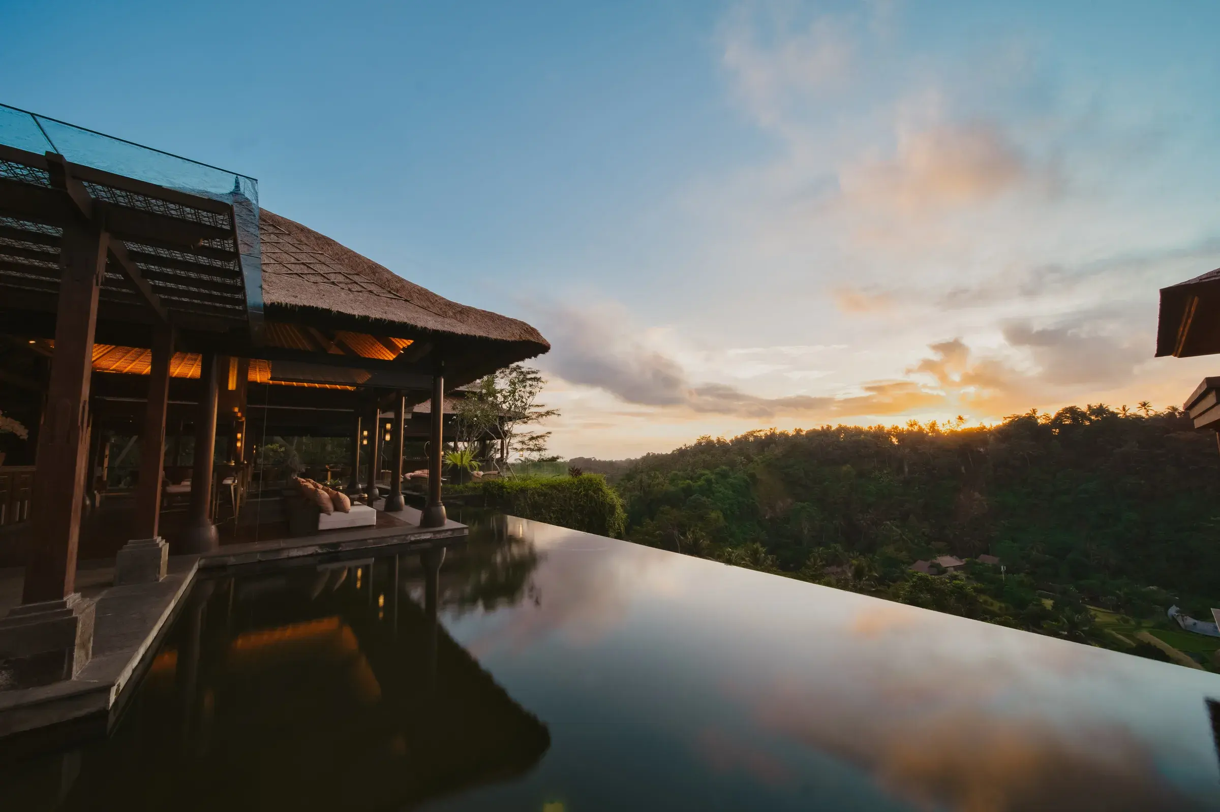Ambar restaurant pavilion at Mandapa, a Ritz-Carlton Reserve, reflected in the infinity pool at sunset