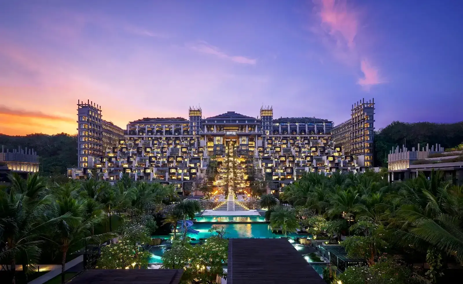 The Apurva Kempinski Bali resort facade and pools glowing at sunset in Nusa Dua.