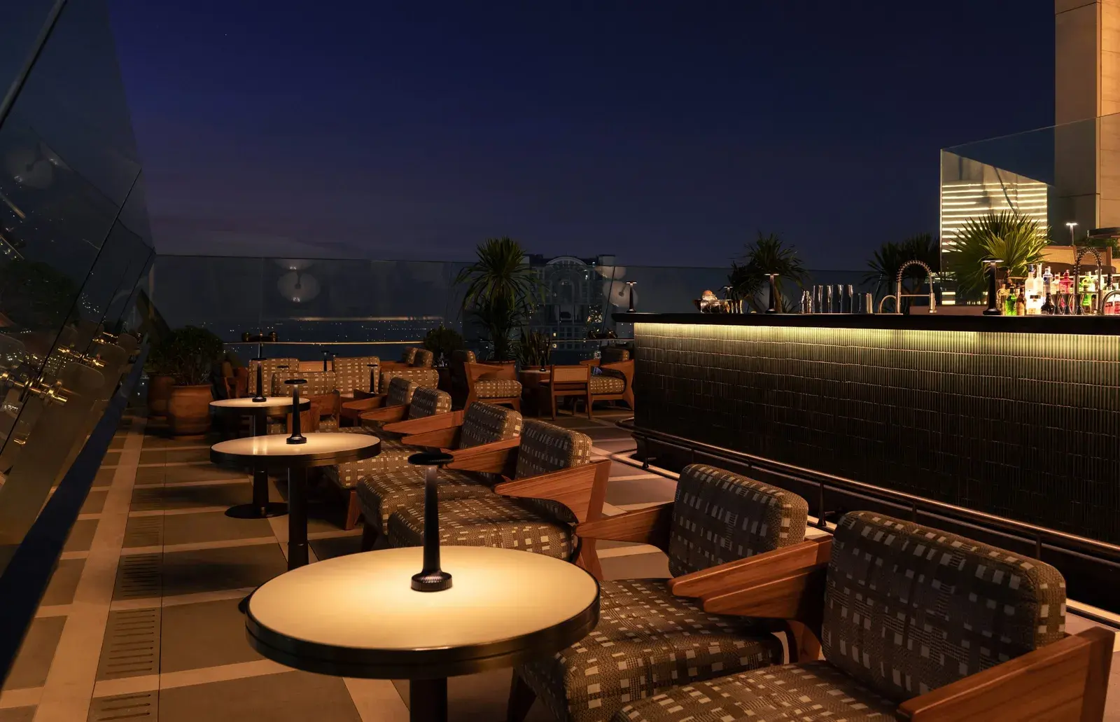 Window seating at Spire Rooftop Bar, Dusit Thani Bangkok, overlooking the Bangkok skyline
