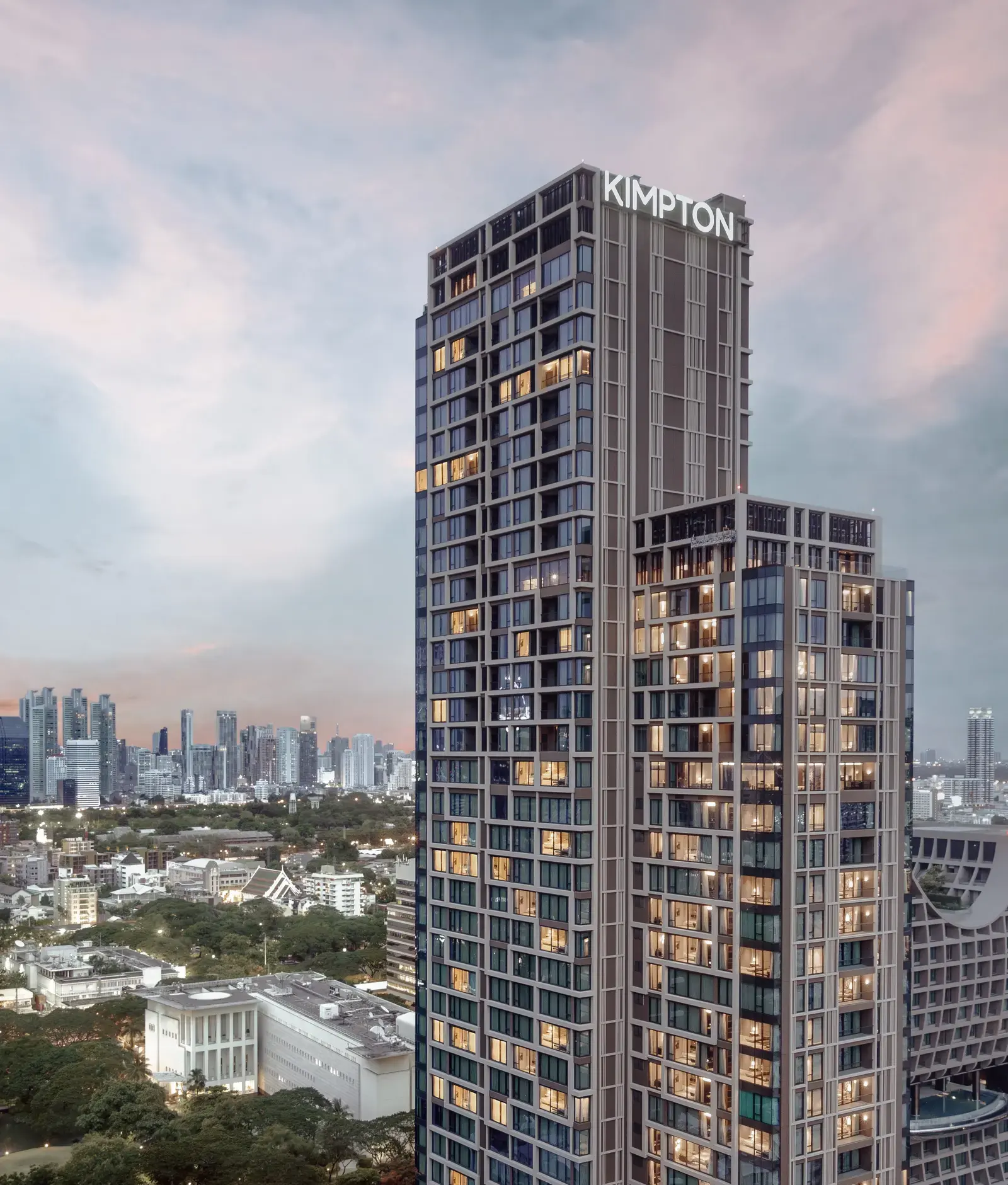 Exterior view of Kimpton Maa-Lai Bangkok's tower against the Bangkok skyline