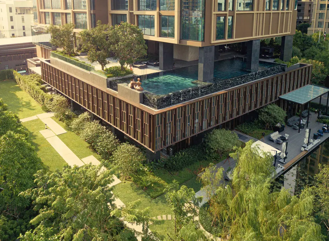 Rooftop pool at Kimpton Maa-Lai Bangkok overlooking the hotel's green facade