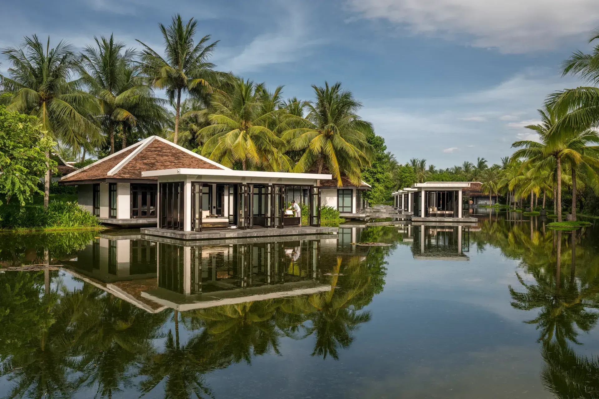 Villa at dusk reflecting in water at Four Seasons Resort The Nam Hai, Vietnam