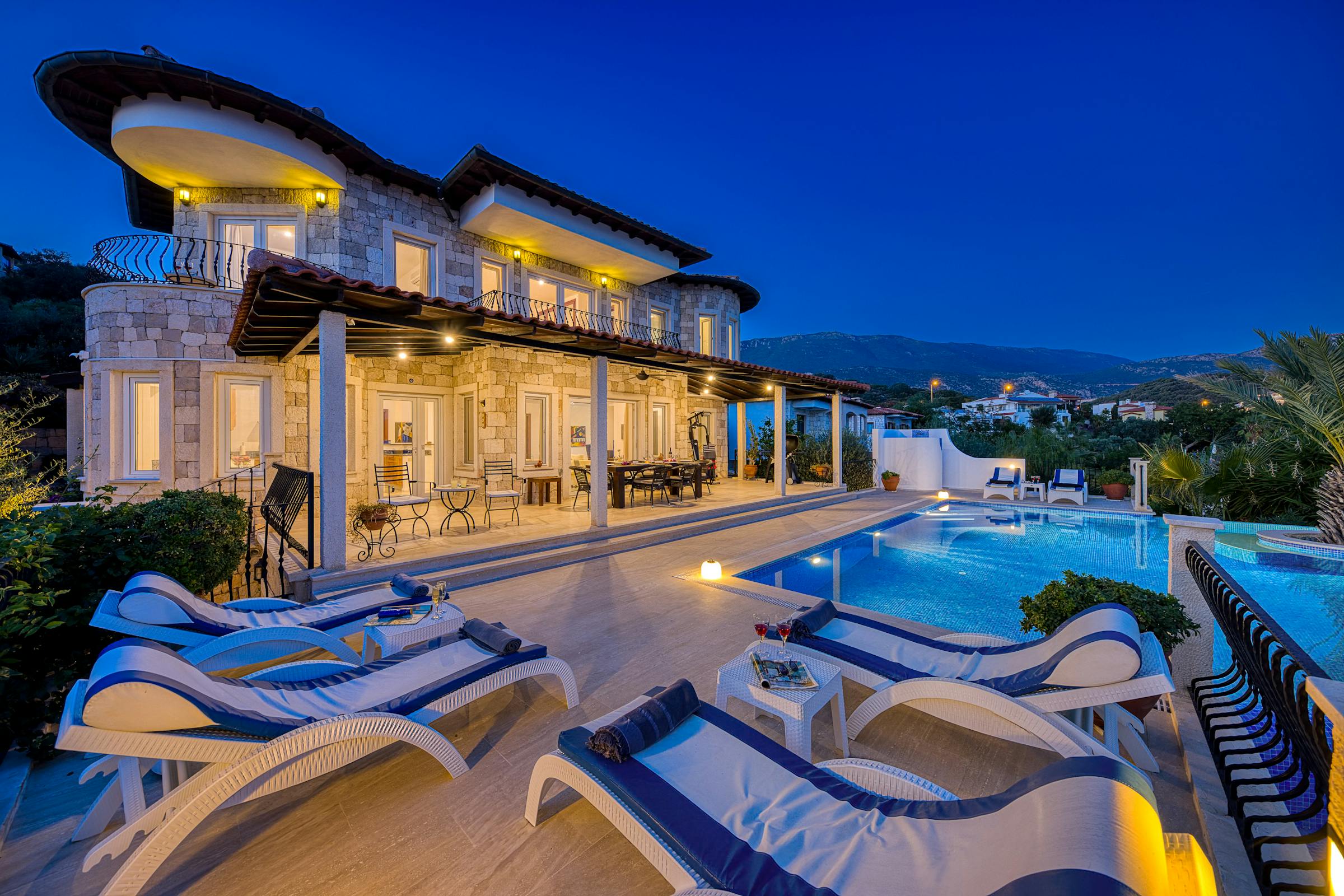Illuminated villa and pool at dusk