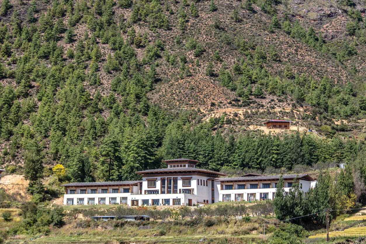 Bhutan Spirit Sanctuary's traditional-style lodge building set against the forested slopes of the Neyphu Valley near Paro